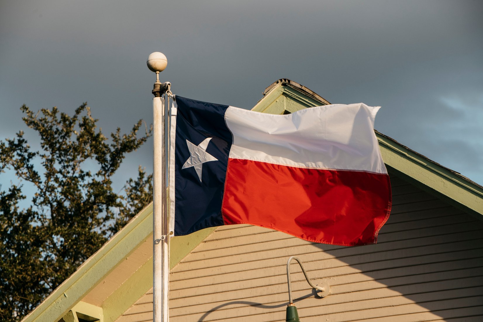 Texas flag flies at farm in Texas at sunset